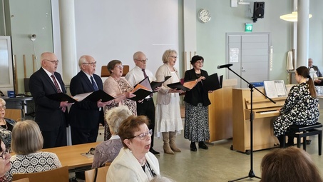 Sketsiryhmä esitti Äitienpäivän kunniaksi Naisen elämänkaari -kuvaelman.  Emma Kurkinen säesti. Myös yleisö intoutui laulamaan.